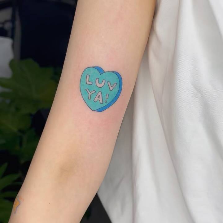 Sweetheart tattoo located on the bicep, illustrative style.