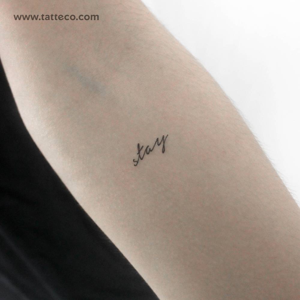 Handwritten font word "stay" temporary tattoo located on the inner forearm.