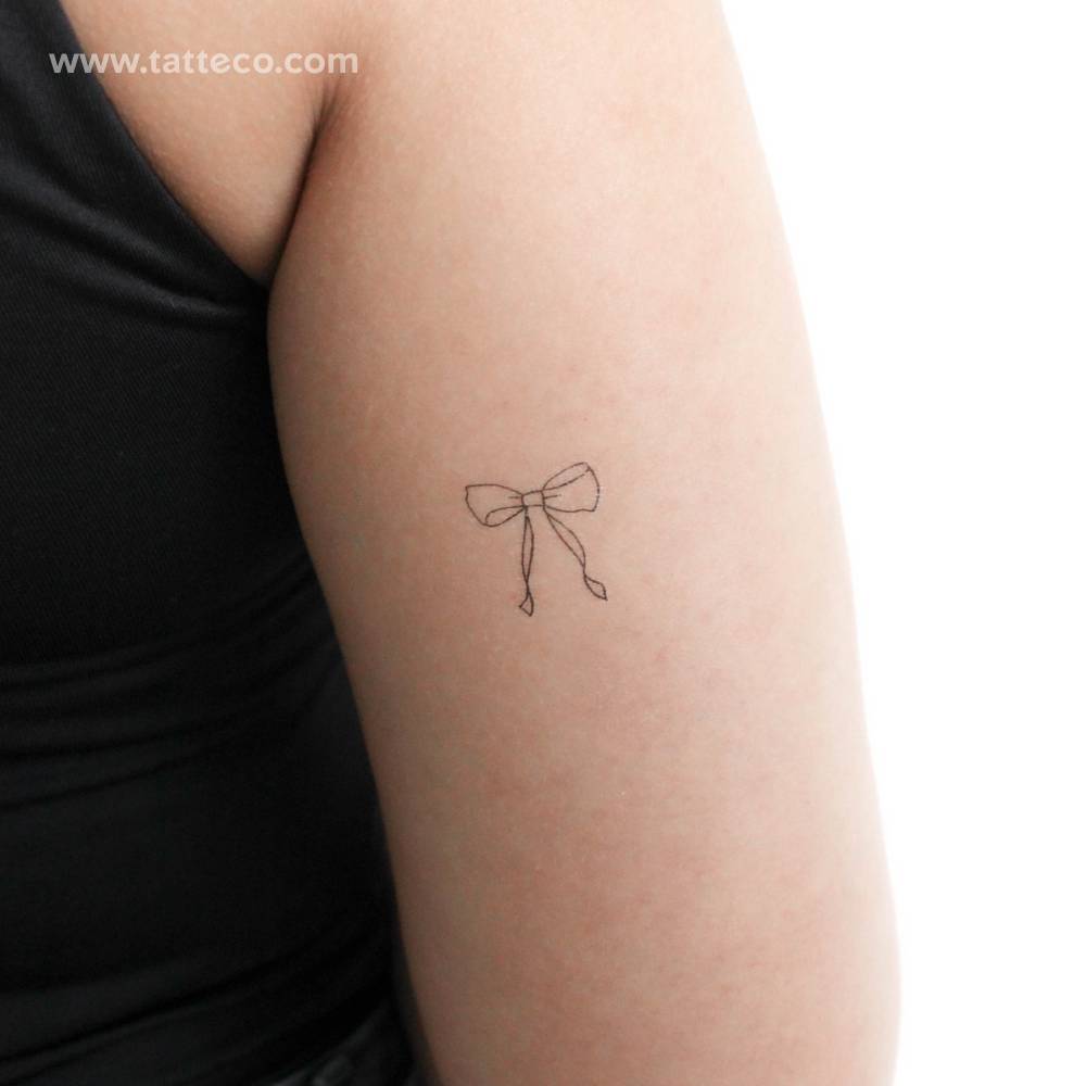 Fine line style bow temporary tattoo located on the tricep.