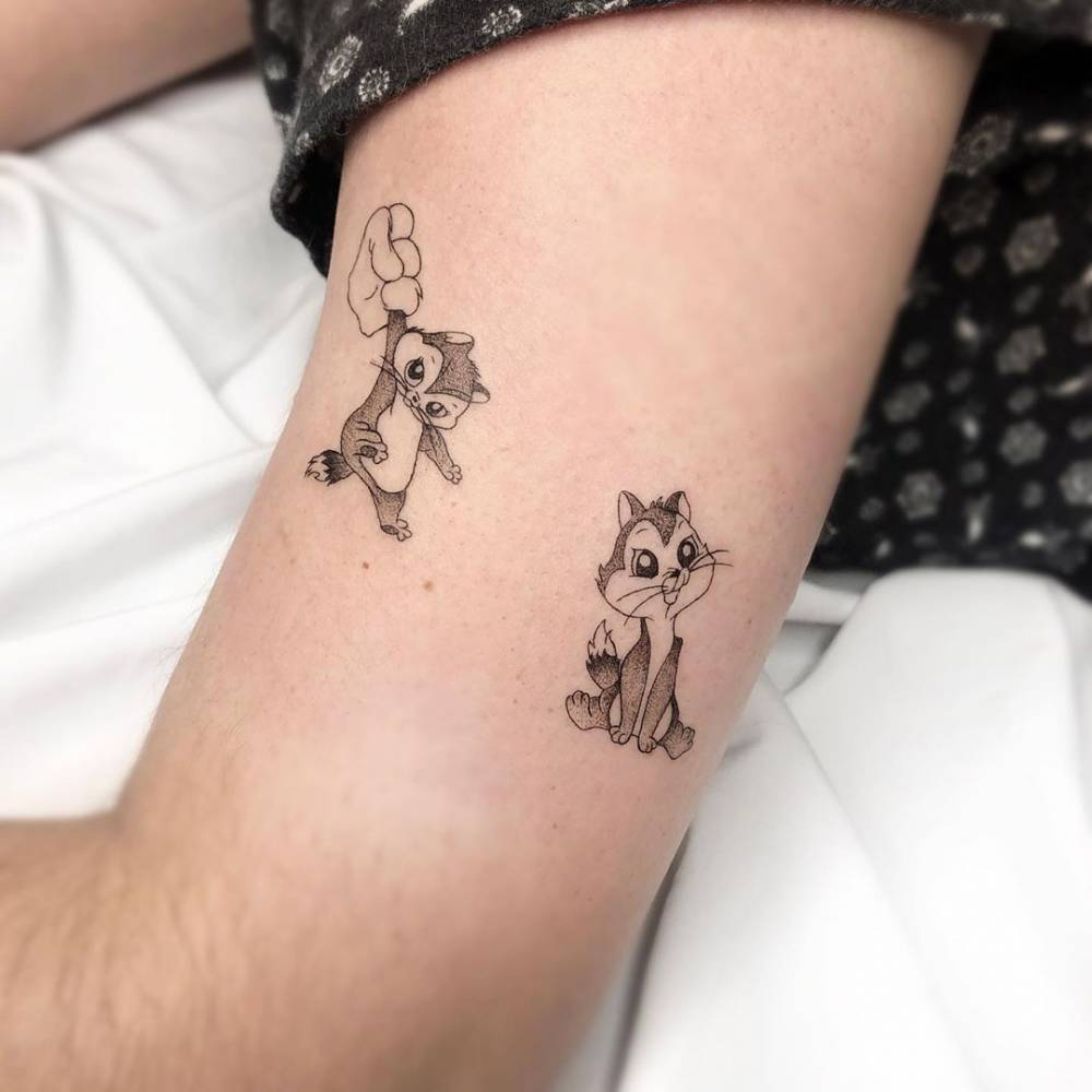Pussyfoot tattoo in cartoon style located on the upper arm.