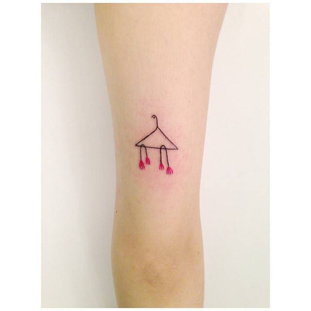 Clothes hanger and flowers tattoo located on the tricep.