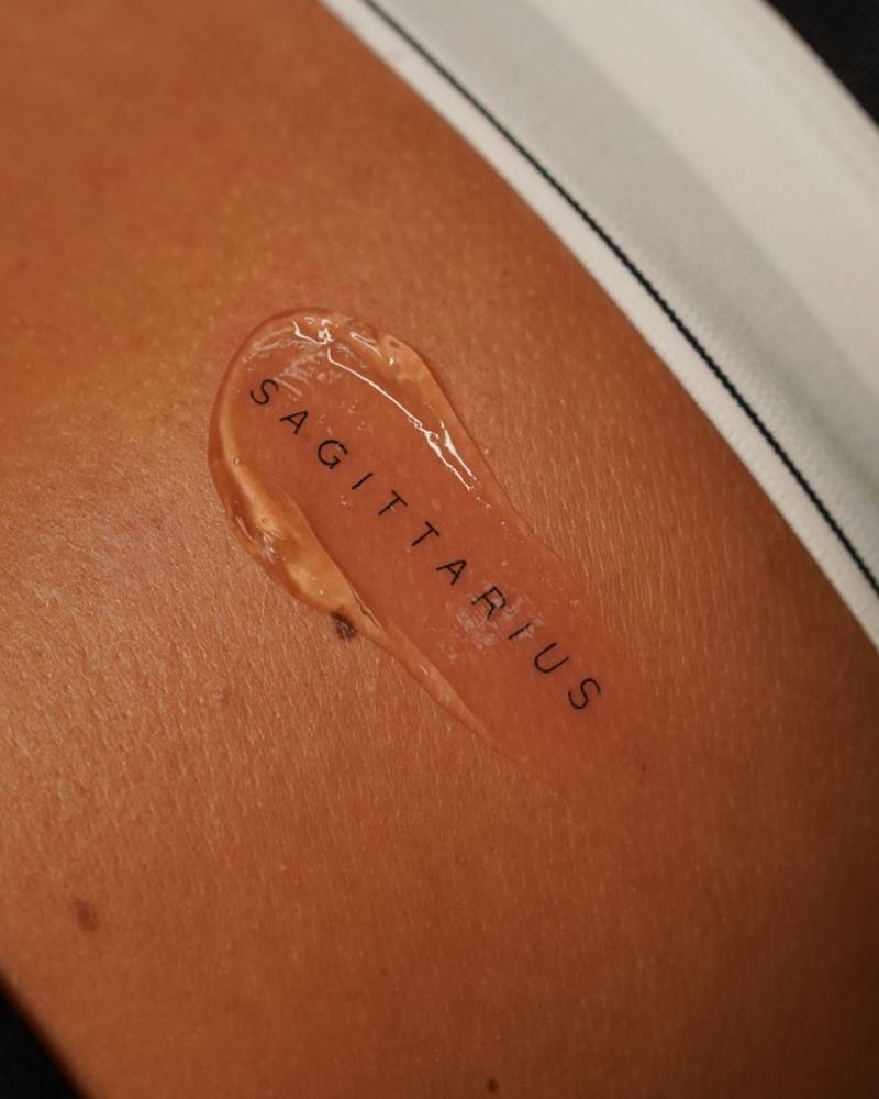 "Sagittarius" lettering tattoo located on the rib.
