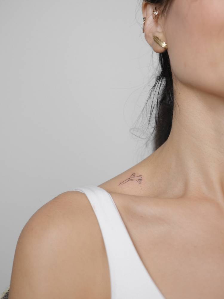 Little flowers tattoo in fine line style located on the top of shoulder.