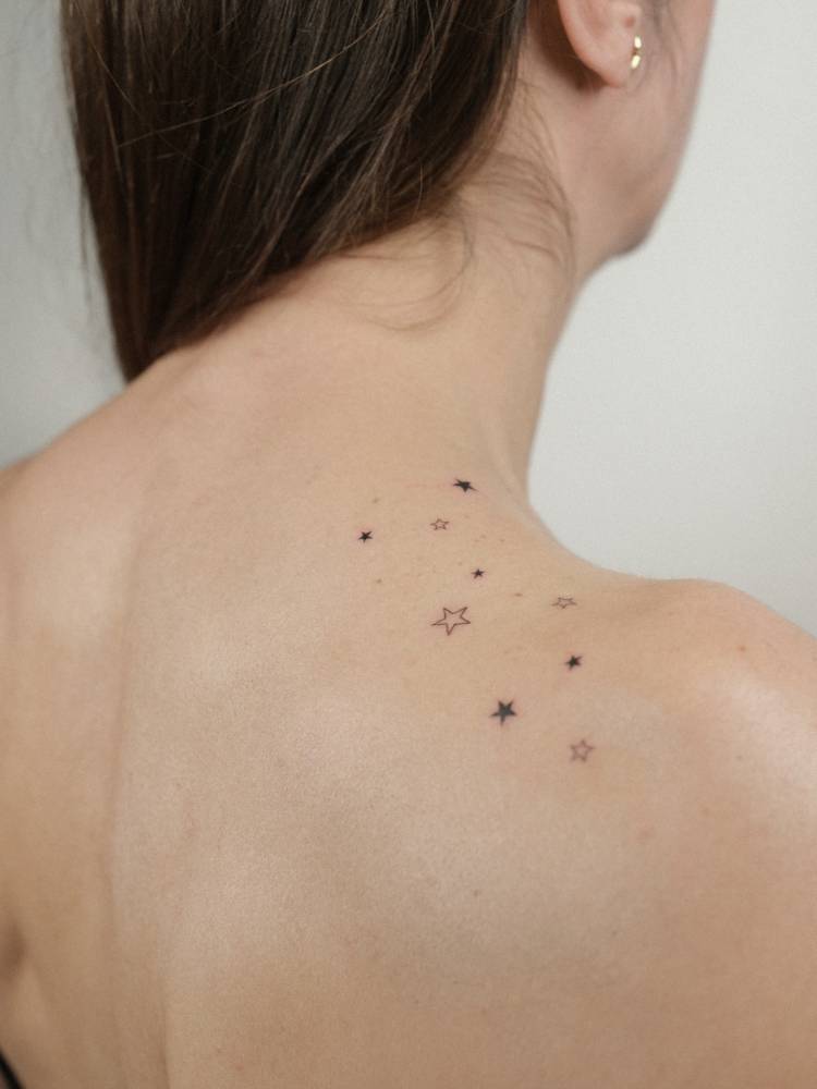 Star collection in minimalistic style tattooed on the top of shoulder.