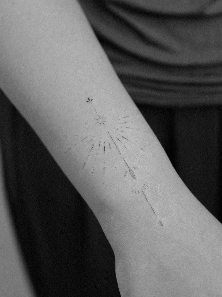 Fine line style ornamental tattoo located on the wrist.