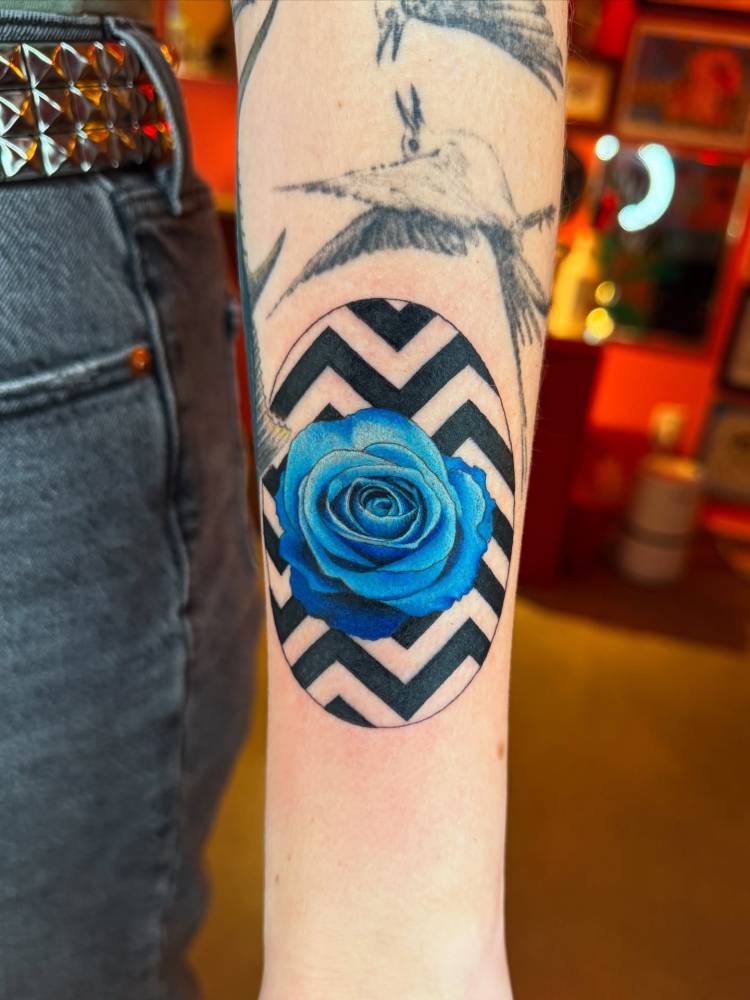 Twin Peaks blue rose tattoo located on the inner forearm.