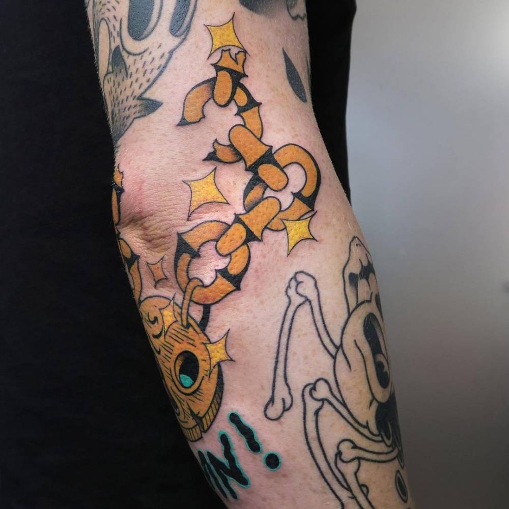 Gold chain tattoo on the elbow