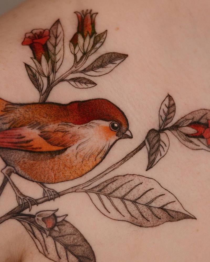 Illustrative bird tattoo on the shoulder.