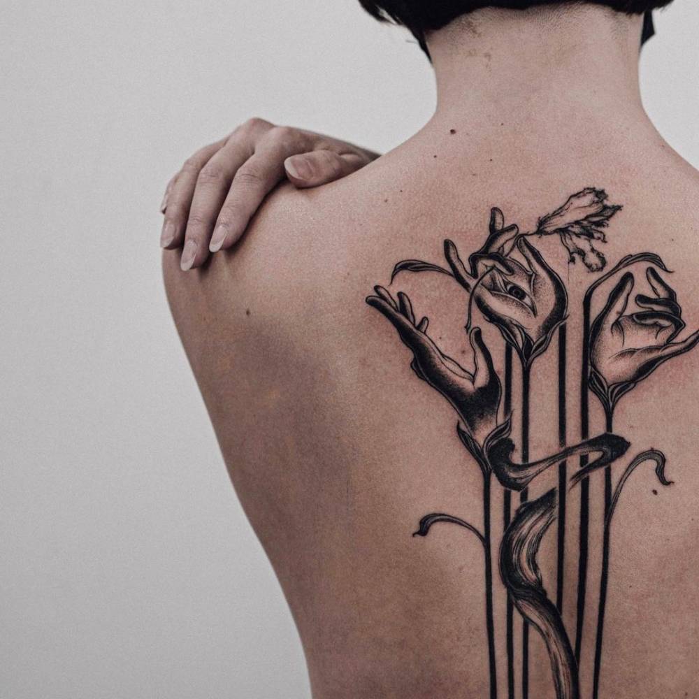 Hands holding flower tattoo on the back