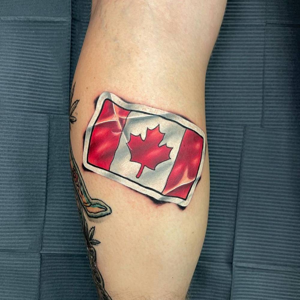 Canadian flag sticker tattoo on the calf.