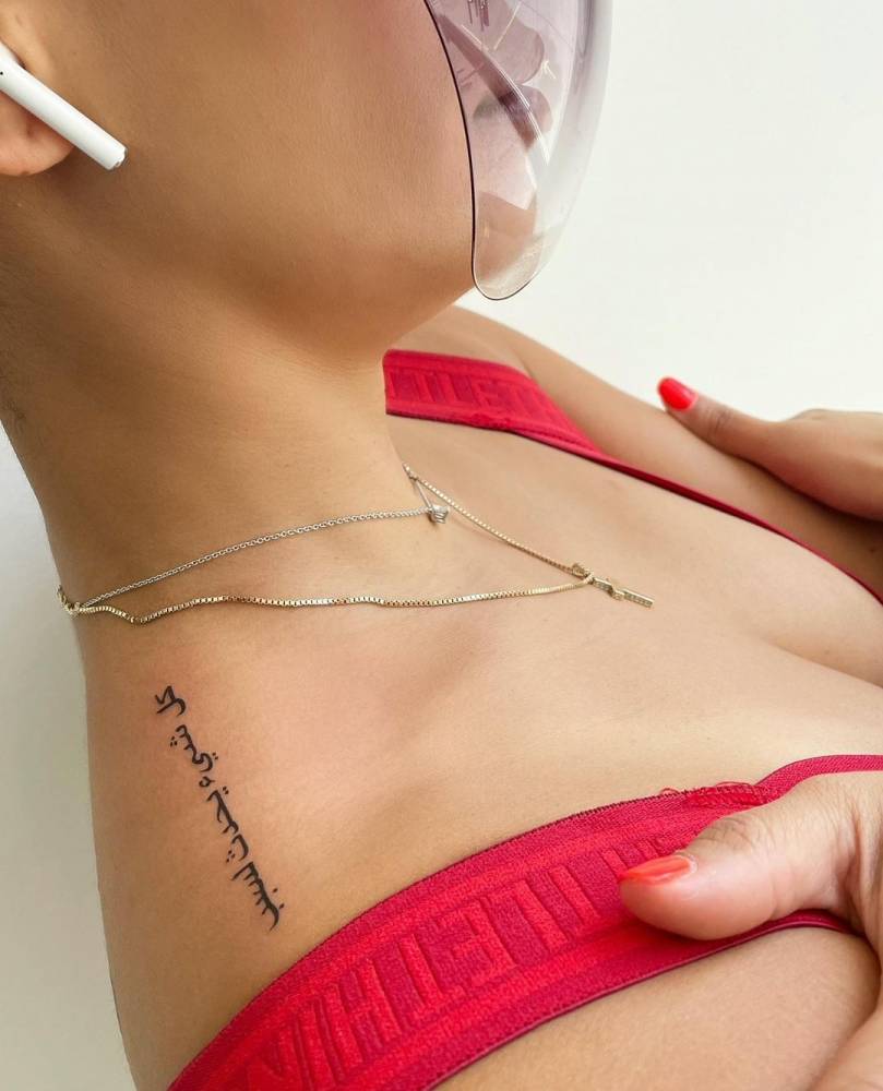 Lettering tattoo on the top of shoulder.