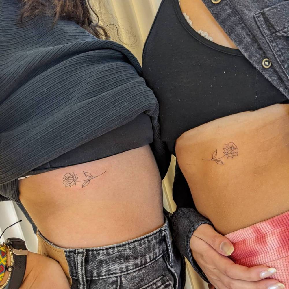 Matching rose tattoo on the ribs for sisters.