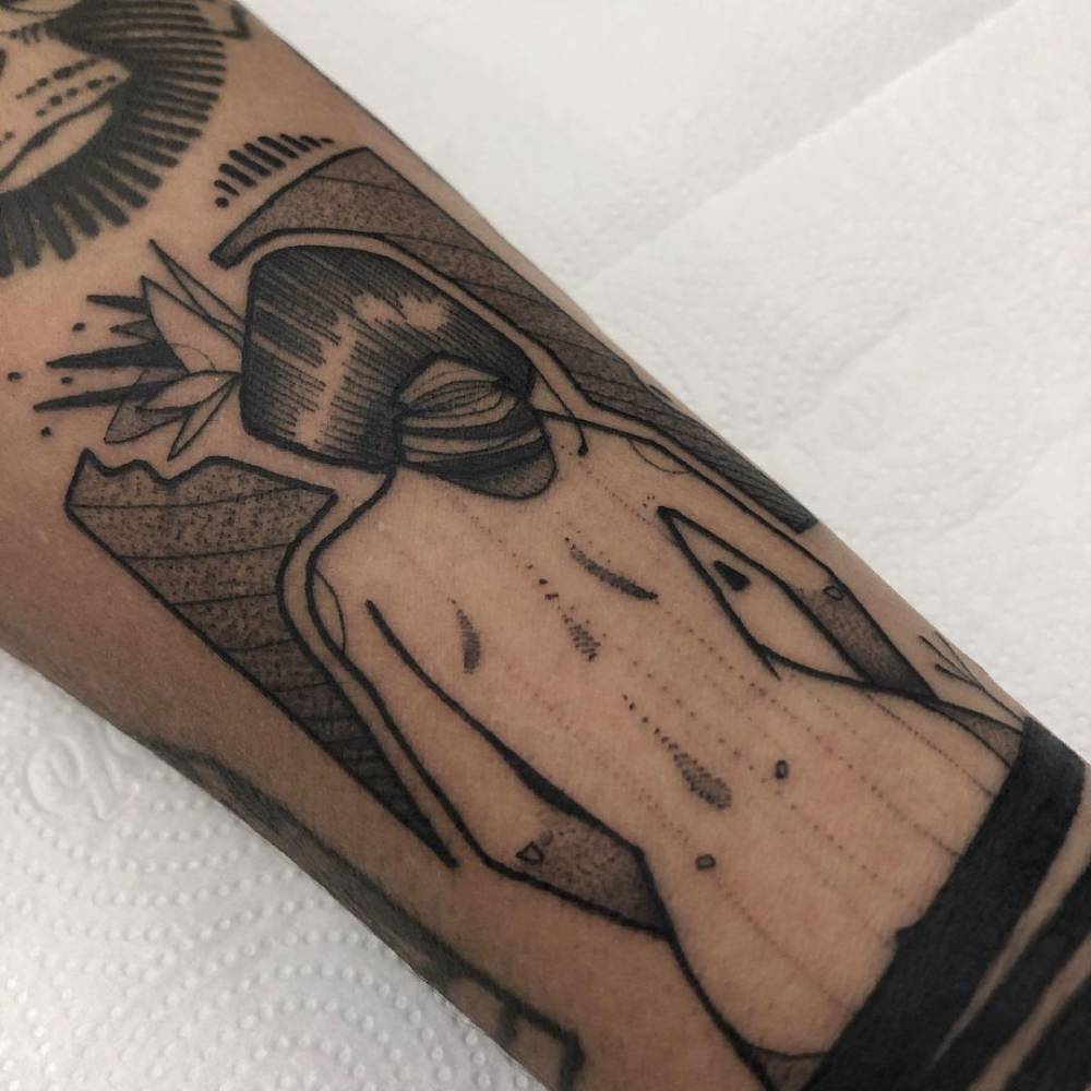 Blackwork nude woman tattoo on the inner forearm.