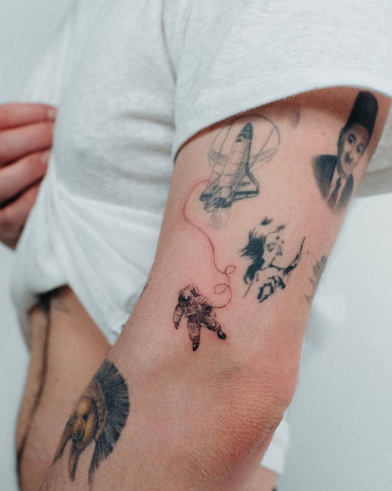 Micro-realistic astronaut tattoo located on the elbow.