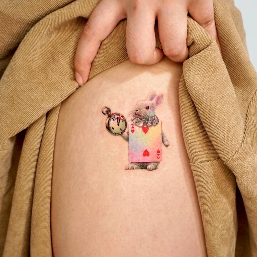 Realistic style White Rabbit tattoo located on the thigh.