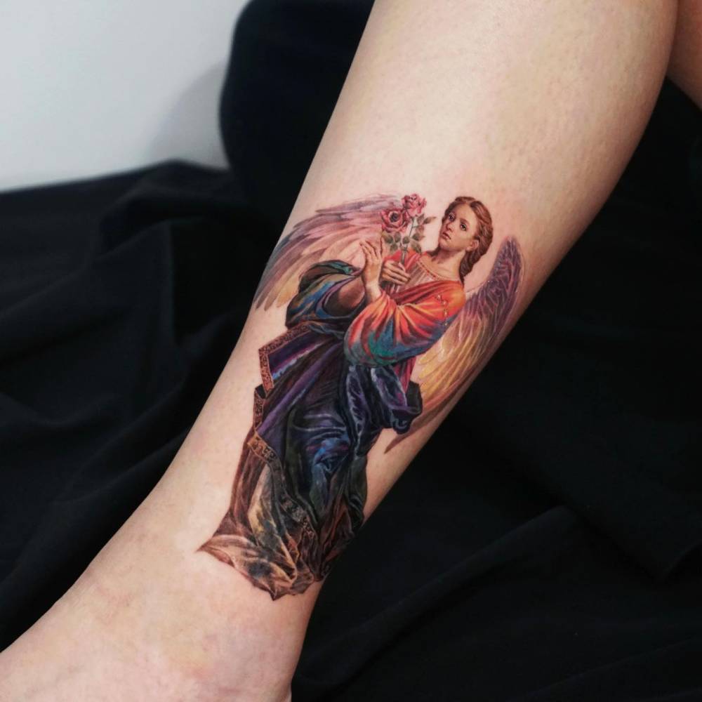 Realistic style angel tattoo located on the ankle.