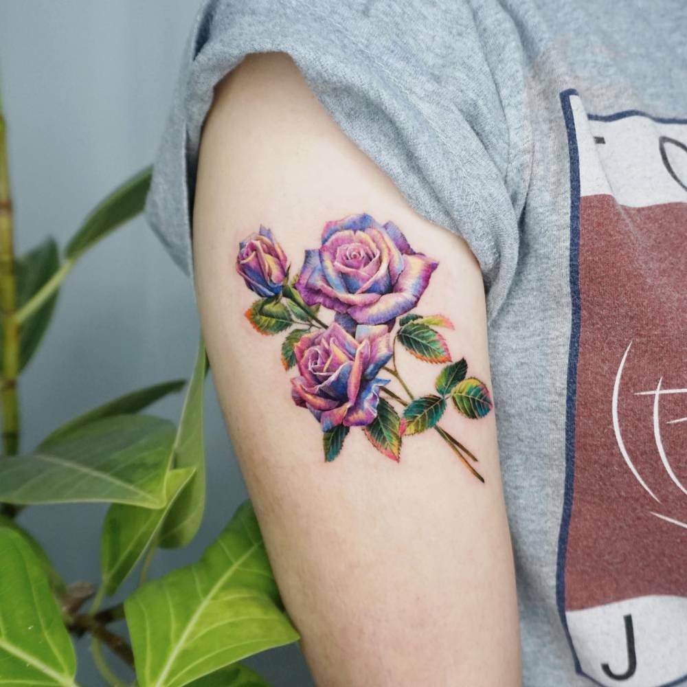 Pink roses tattoo in realism located on the upper arm.