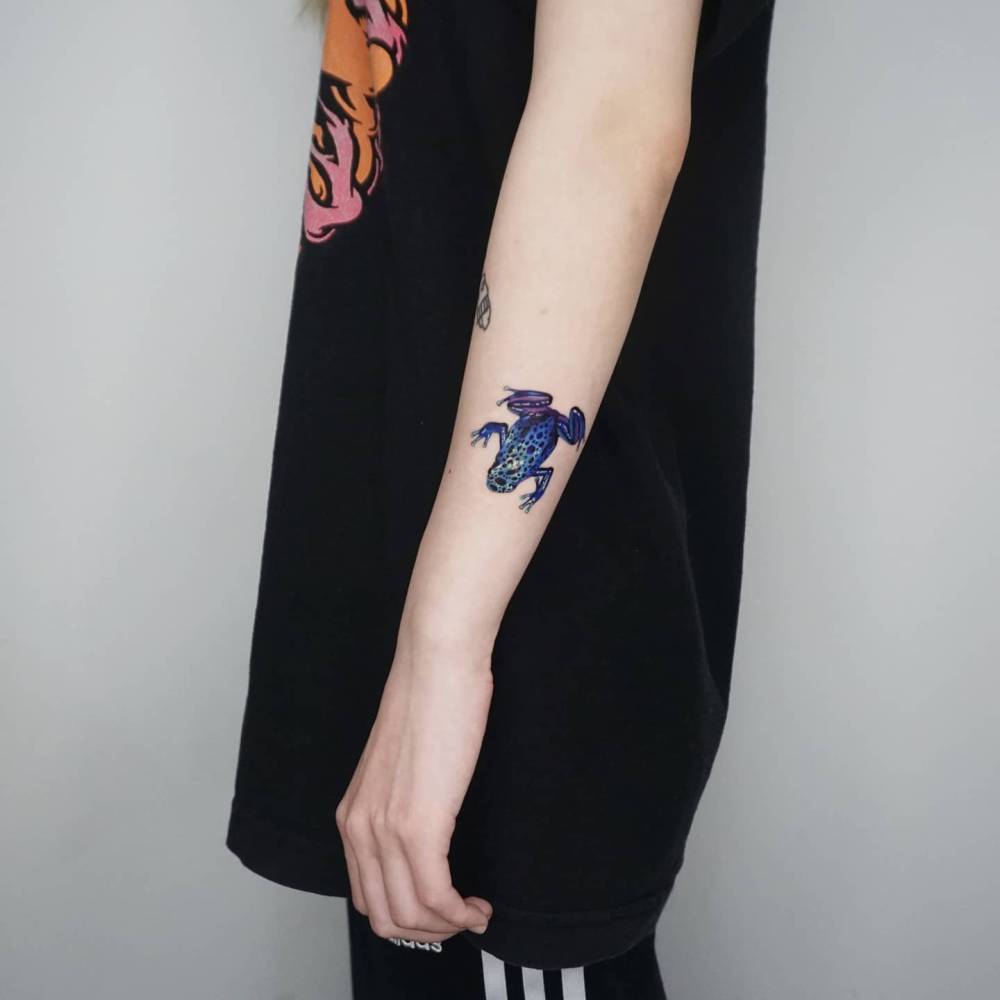 Realistic style frog tattoo located on the forearm.