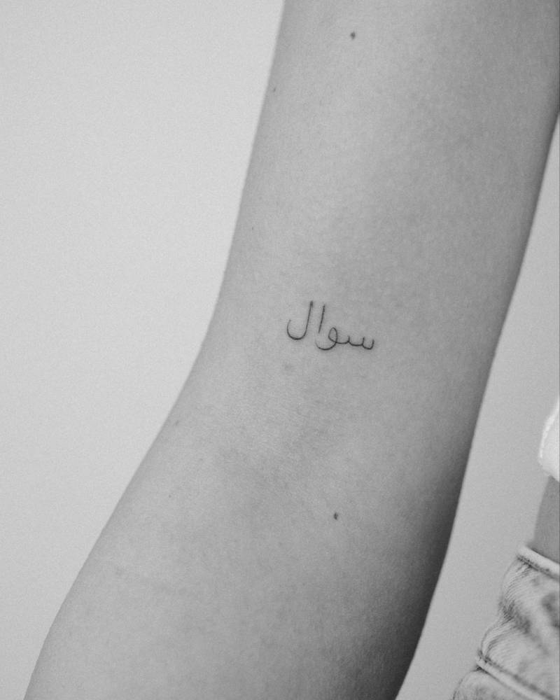 Arabic lettering (The word means "Question" or "Query") tattoo placed on the bicep.