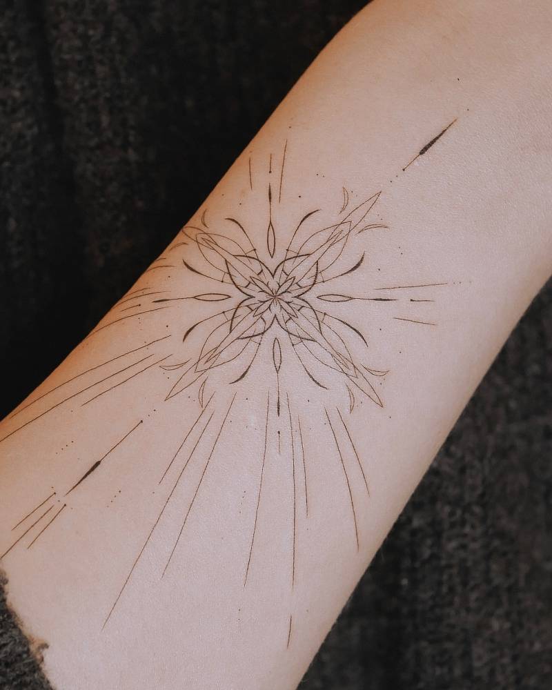 Ornamental design tattooed on the wrist, done in fine line style.