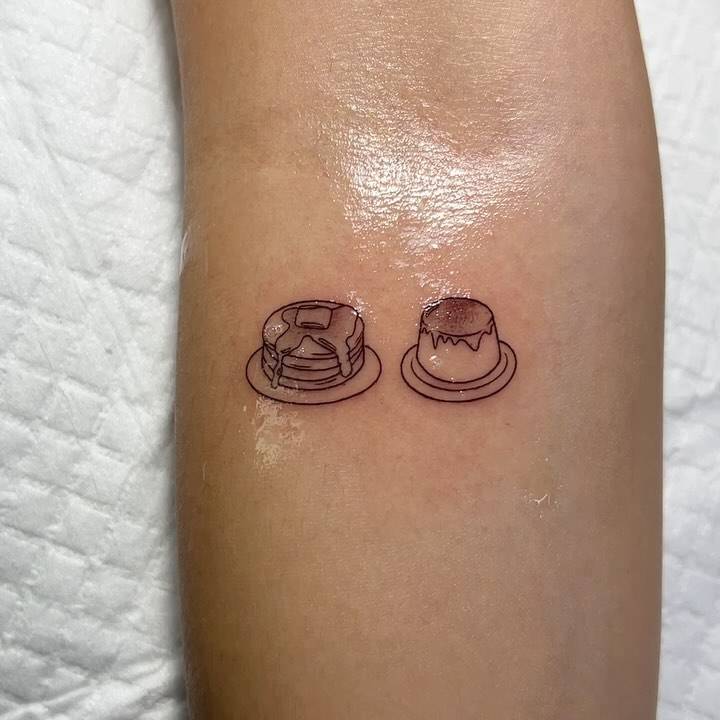 Pancake and pudding tattoo located on the inner forearm, minimalistic style.