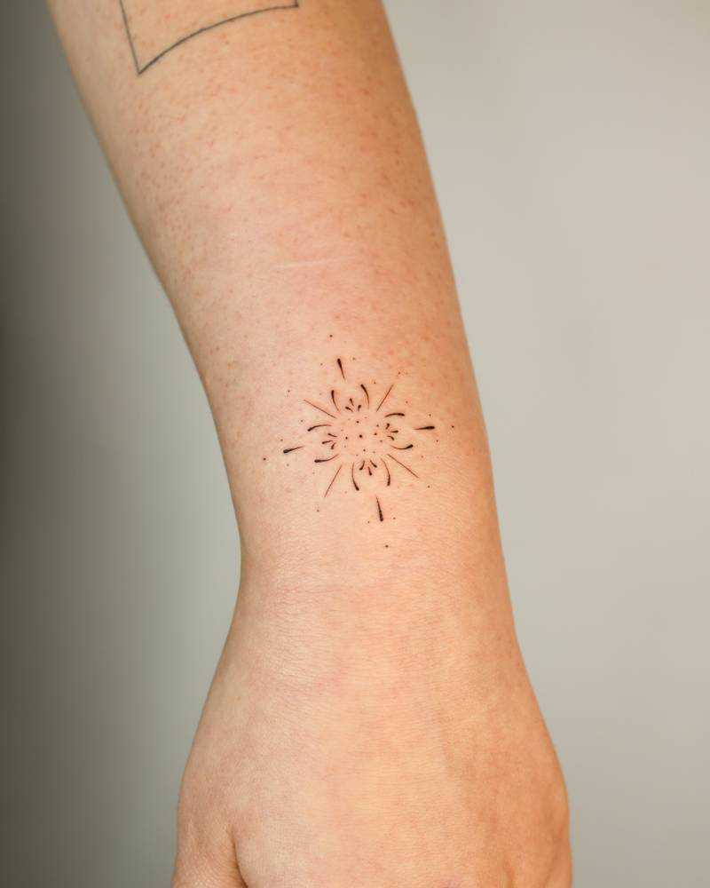 Little ornament tattoo placed on the wrist.