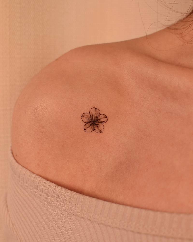 Illustrative style cherry blossom tattoo located on the shoulder.