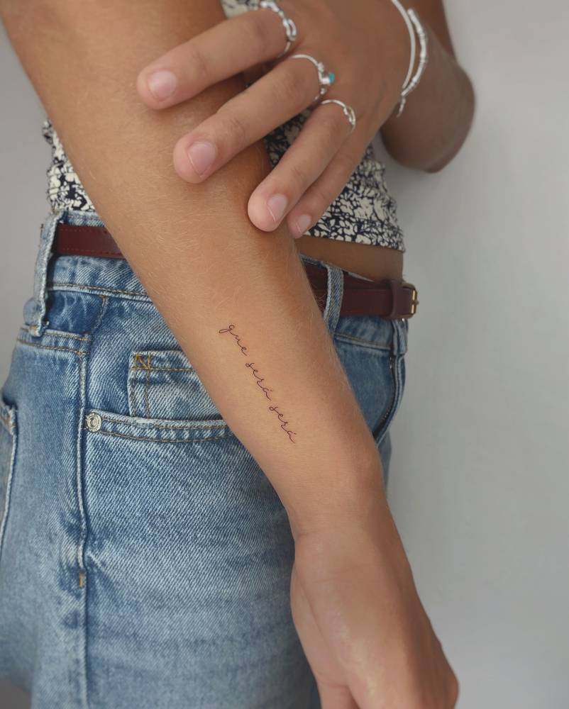 "Que sera, sera" lettering tattoo handwritten on the wrist.