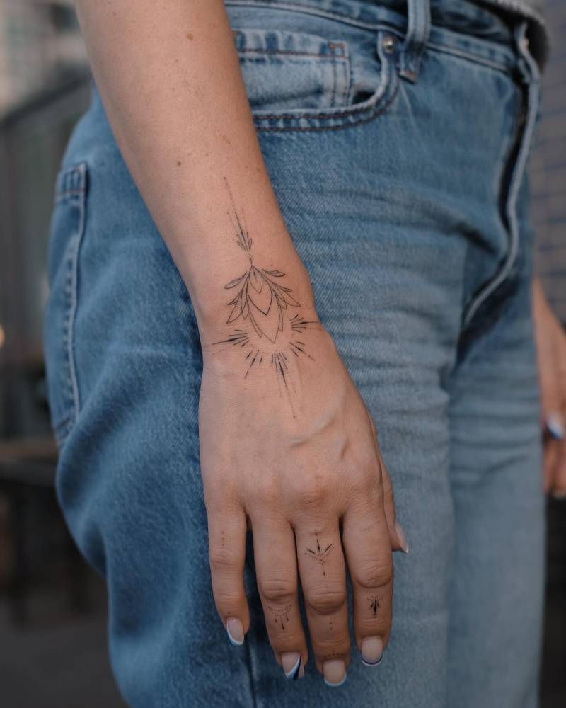 Hand poked ornamental lotus flower tattoo placed on the wrist.