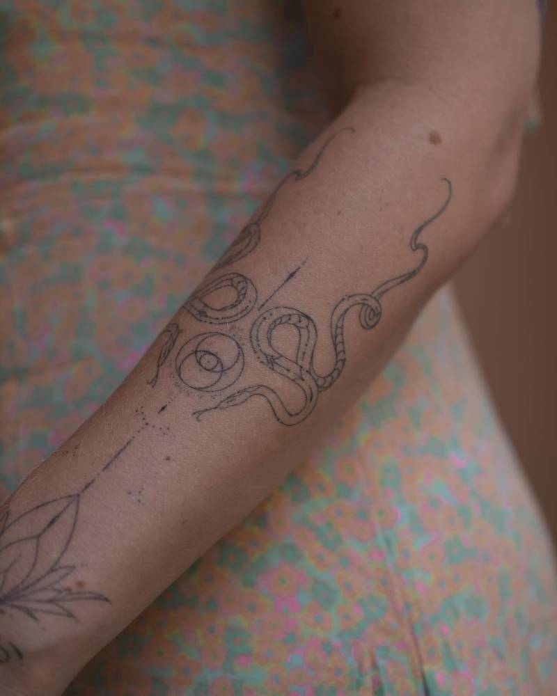 Hand poked ornamental snake tattoo located on the forearm.