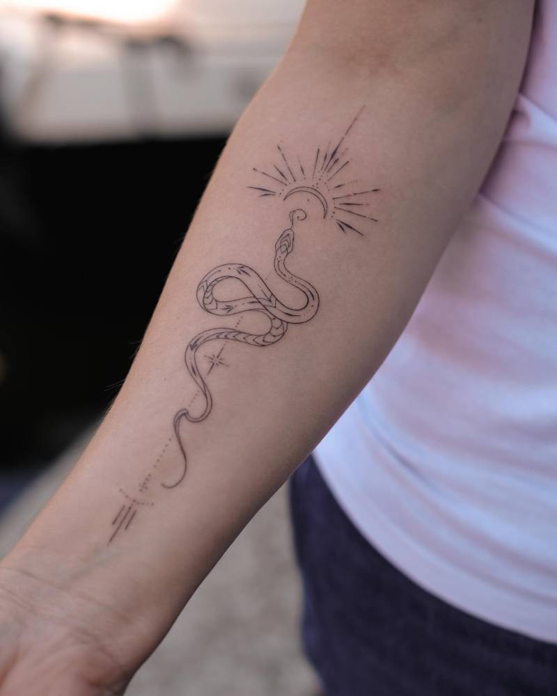Hand poked ornamental snake tattoo placed on the inner forearm.