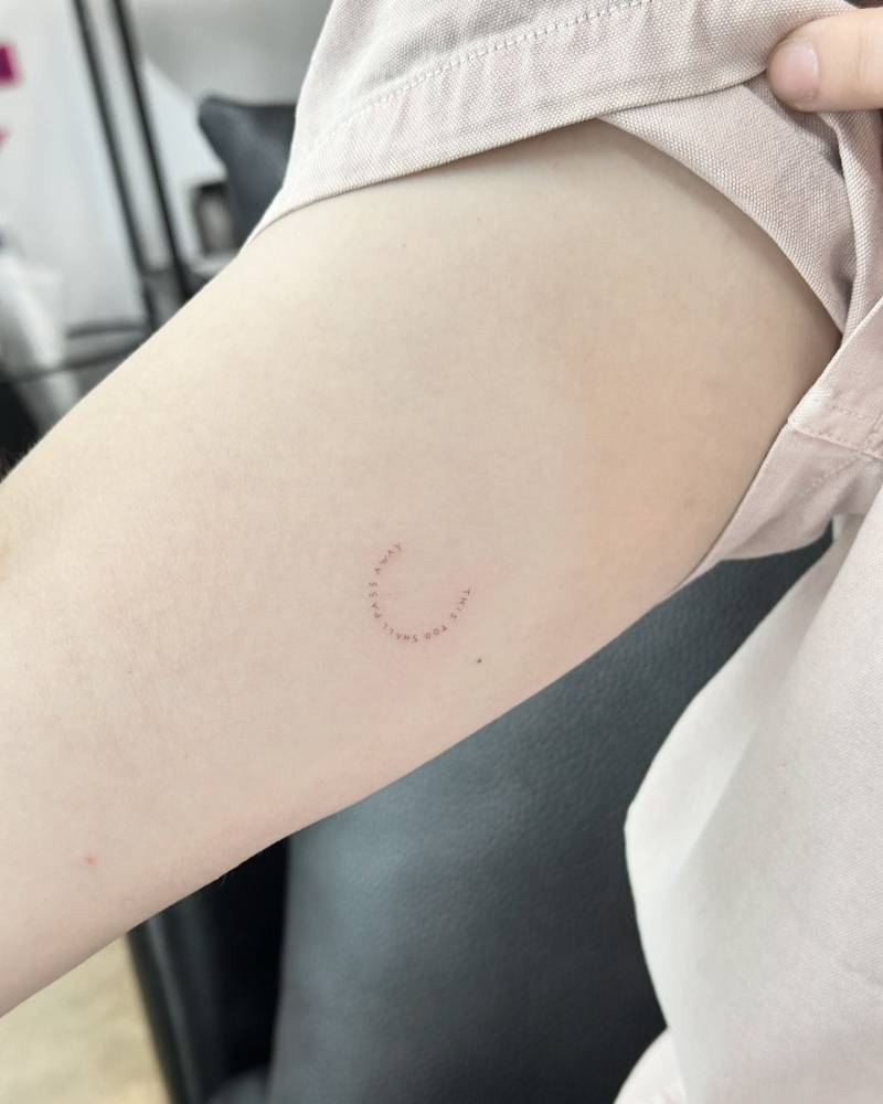 "This too shall pass away" lettering tattoo located on the inner arm.