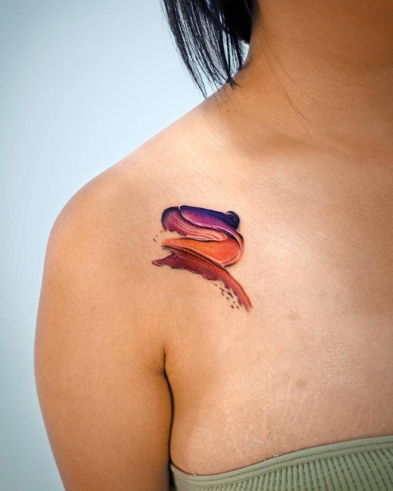 Watercolor style brush stroke tattoo located on the shoulder.