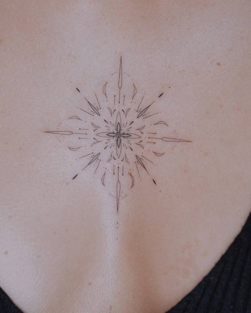 Fine line style ornamental tattoo done on the sternum.
