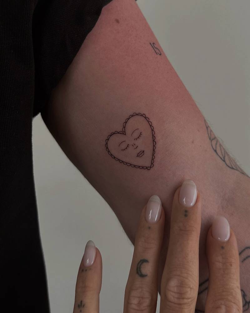 Sleeping heart tattoo in fine line style located on the inner arm.