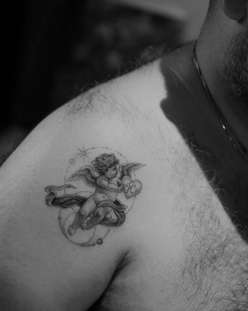 Classical style cherub tattoo located on the shoulder.