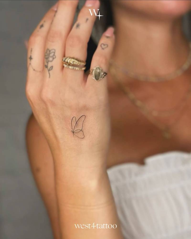 Single line butterfly tattoo located on the hand.