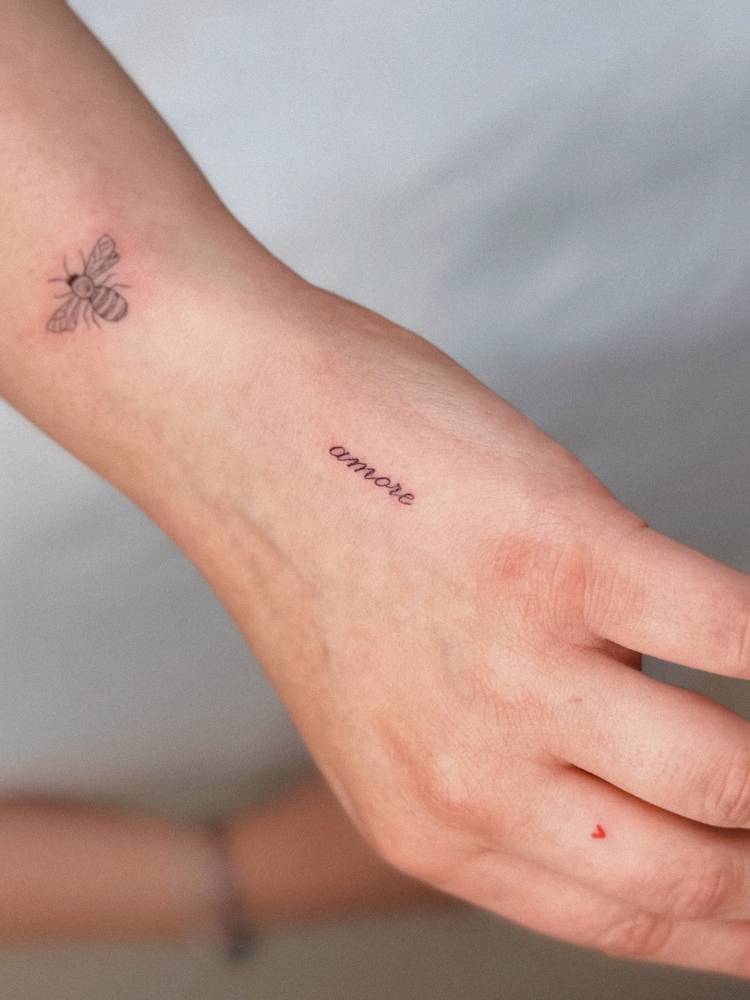 Illustrative style bee and word "amore" tattoos.