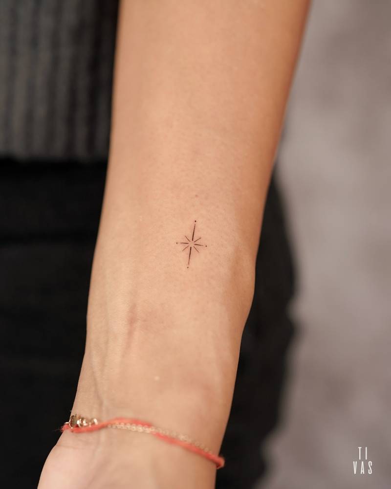 Tiny north star tattoo placed on the wrist, minimalistic style.