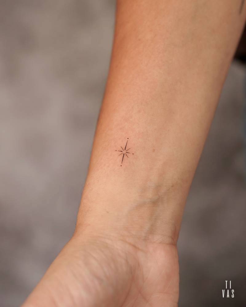 Tiny north star tattoo placed on the wrist, minimalistic style.