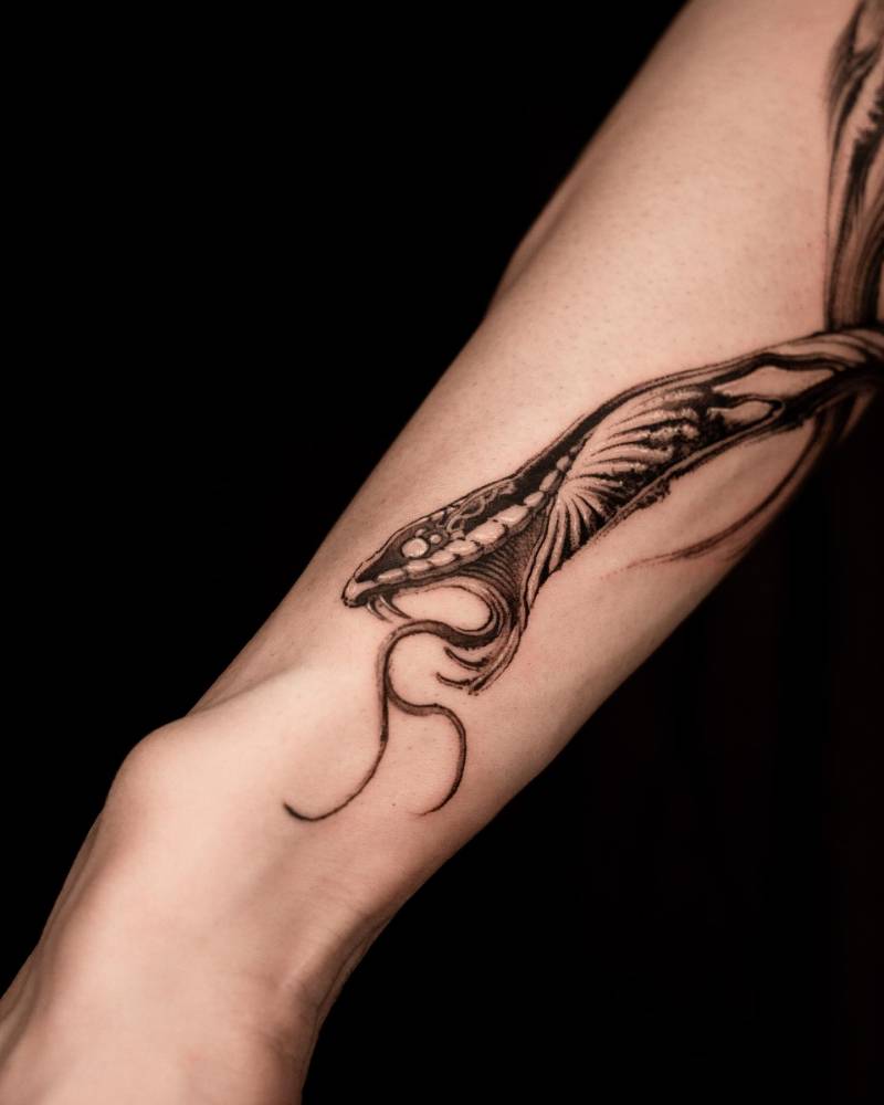 Blackwork style snake tattoo placed on the forearm.