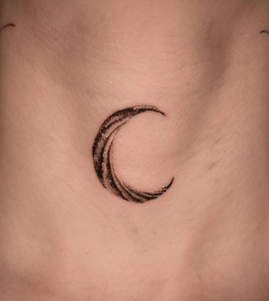Crescent moon in blackwork style located on the throat.