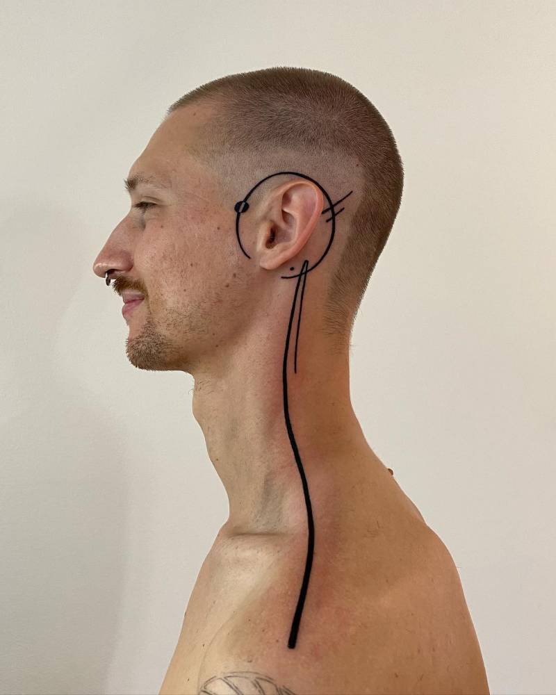 Lines and circle tattoo located on the head and neck, done in geometric style.