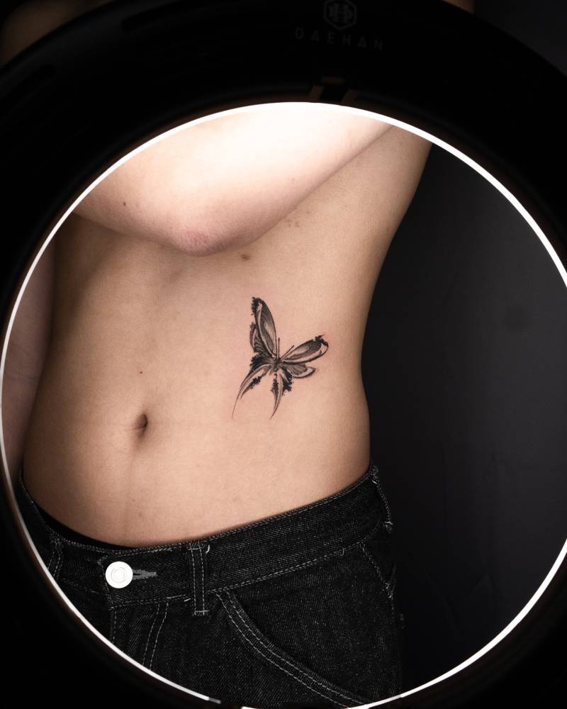 Watercolor style butterfly tattoo done on the waist.