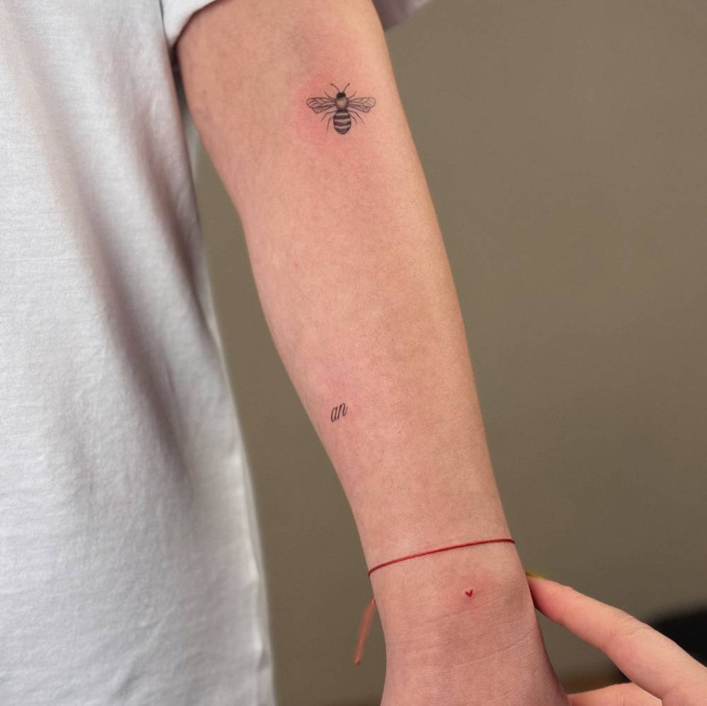 Illustrative style bee tattoo located on the forearm.