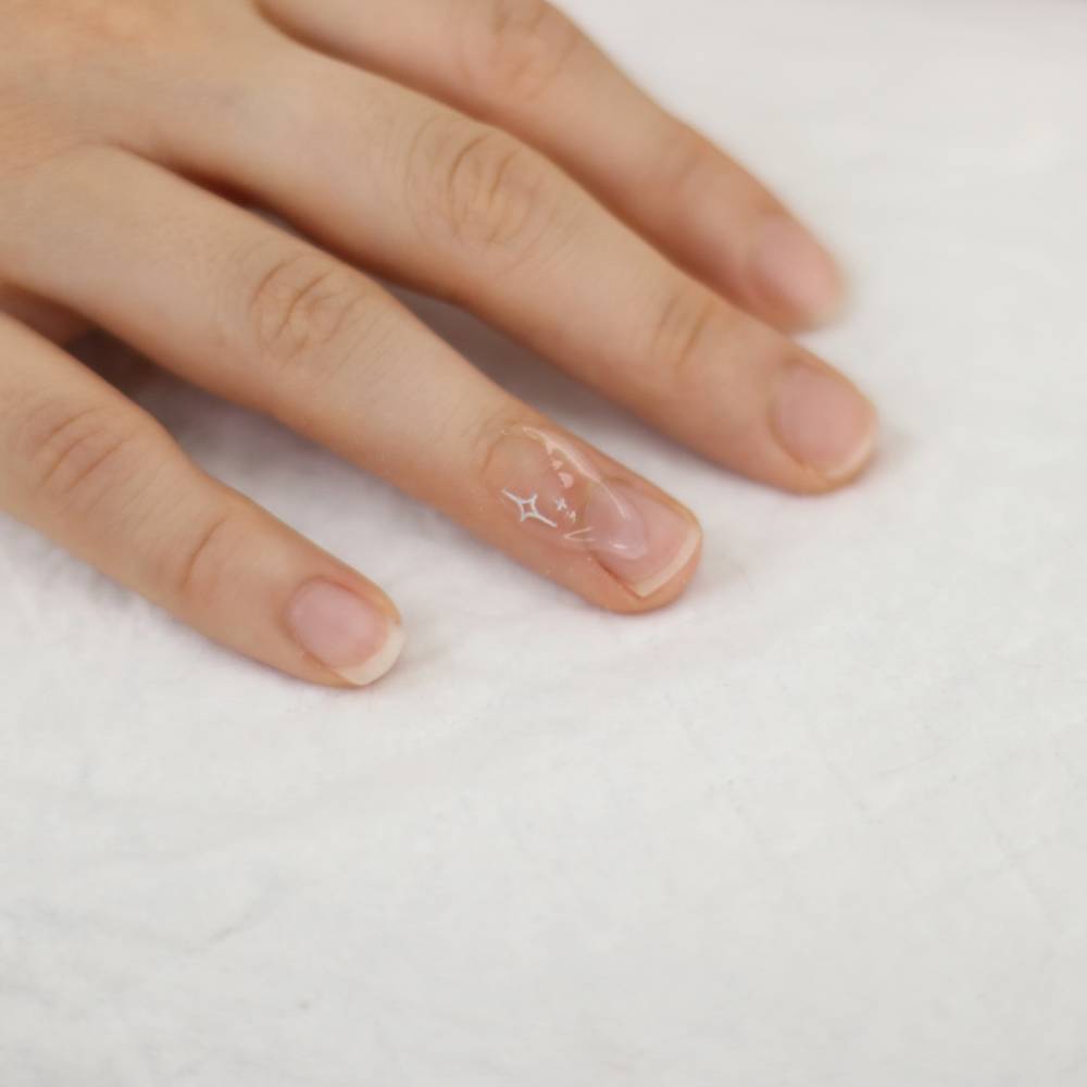 Minimalistic style sparkling stars tattoo in white ink located on the finger.