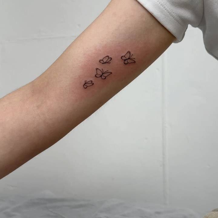 Fine line style butterfly collection tattoo located on the inner arm.