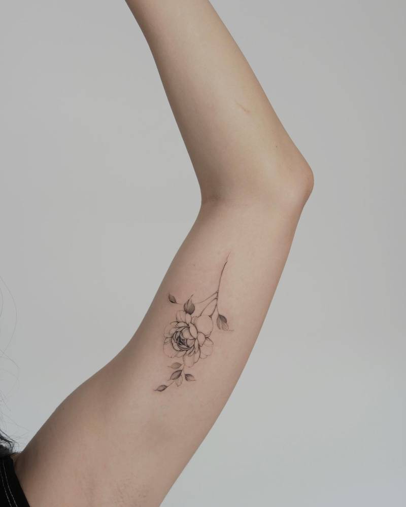 Peony tattoo located on the inner arm, done in illustrative style