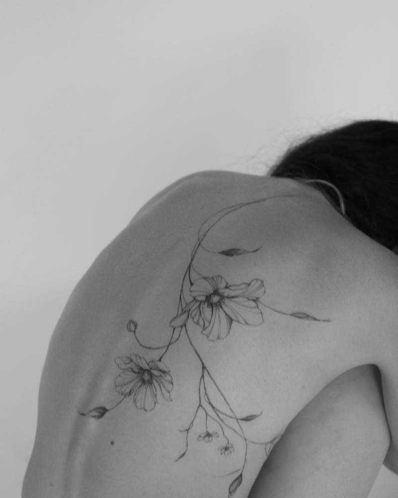 Anemone flower tattoo located on the back.