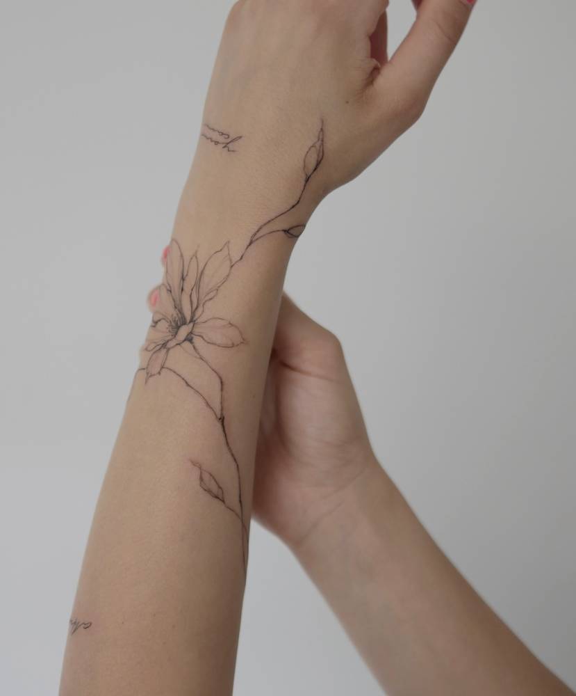Magnolia flower tattoo located on the wrist.